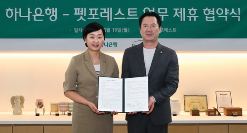 지난 19일 협약식에 참석한 이은정 하나은행 하나더넥스트본부장(왼쪽)이 이상흥 펫포레스트 대표와 함께 협약서를 들고 기념 촬영을 하고 있다. 사진=하나은행